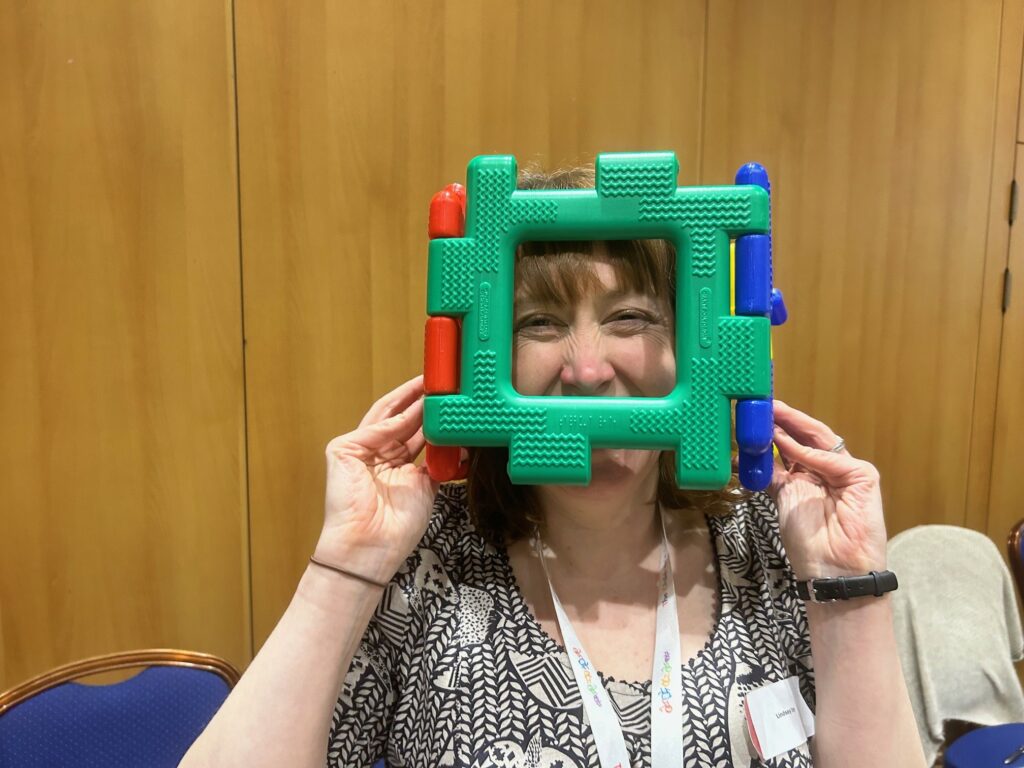 Woman with child's toy over her face and smiling