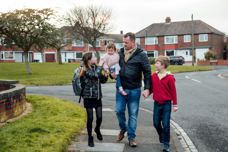 Man with children walking to school