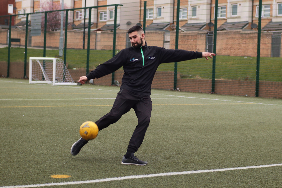 man kicking a football